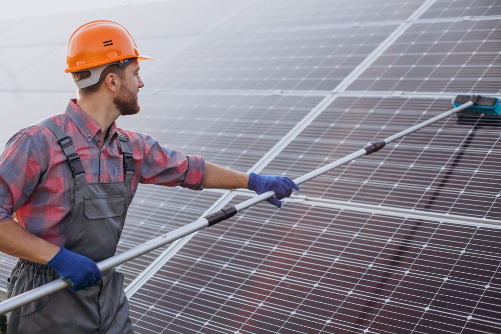 male worker cleaning solar panels scaled 1